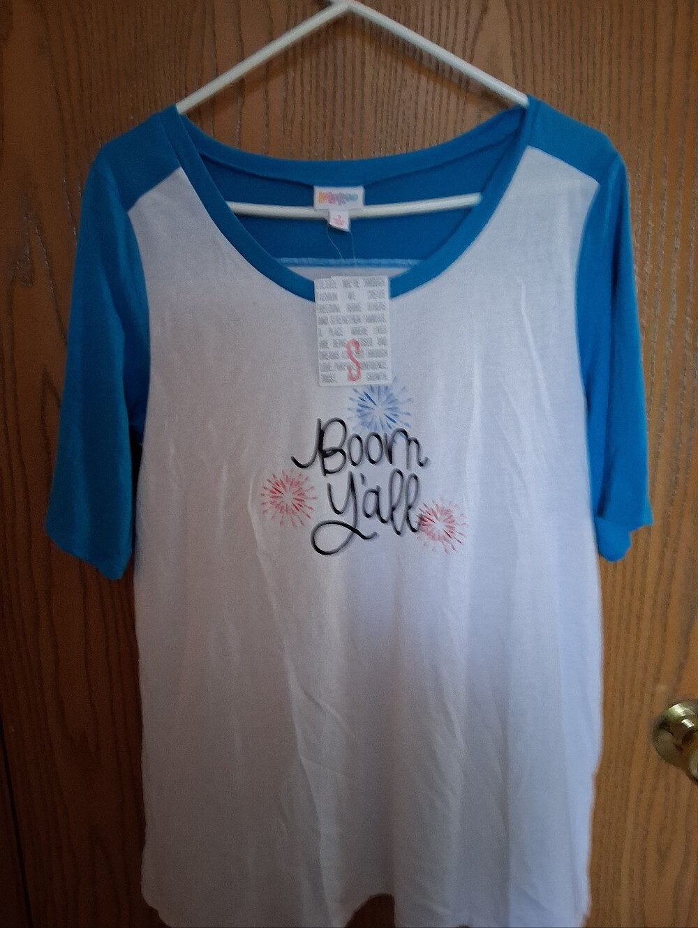 LuLaRoe White Tee with Blue Raglan Sleeves and Firework Design